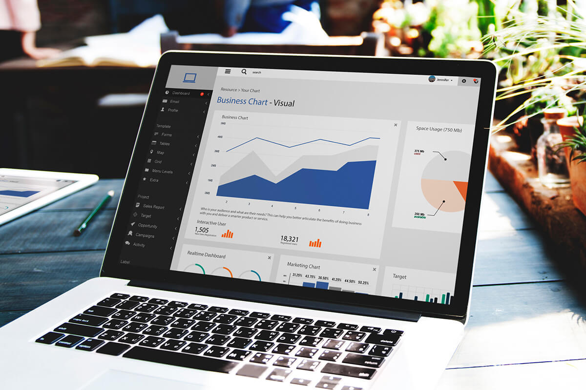 Ein Laptop zeigt ein Unternehmens-Dashboard mit verschiedenen Diagrammen an, darunter ein Linien- und ein Kreisdiagramm