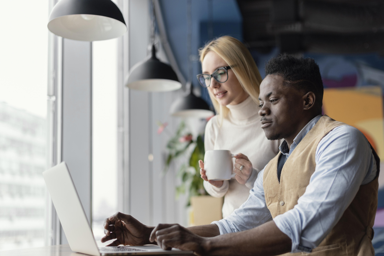 Homem e mulher analisando juntos informações em notebook
